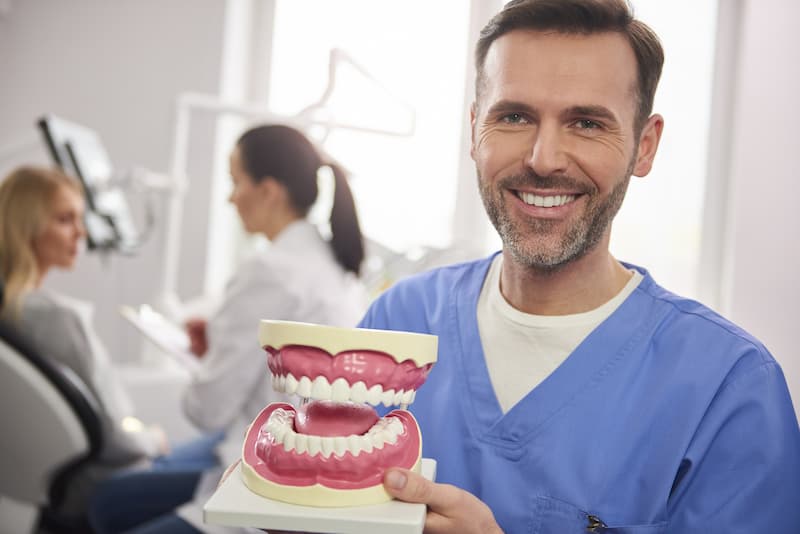 Ayudas para prótesis dentales de la Junta de Andalucía.
Protésico dental mostrando un ejemplo de prótesis dentales para mayores.